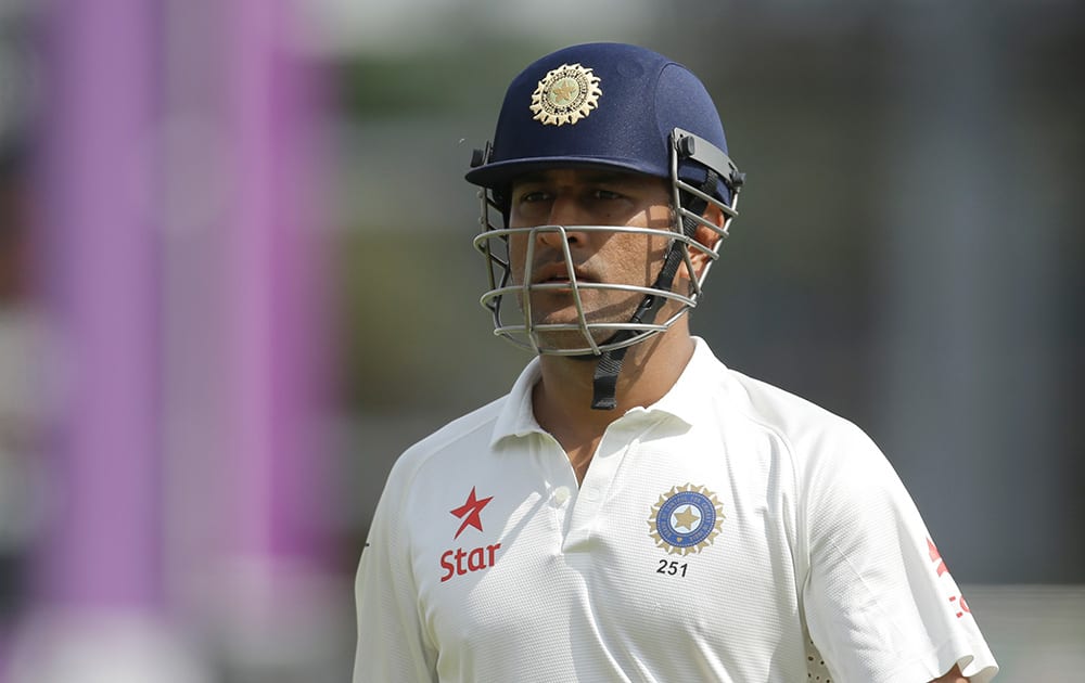 India's captain and wicketkeeper Mahendra Singh Dhoni walks off the field of play after losing his wicket off the bowling of England's James Anderson during the fifth and final day of the third cricket Test match of the series between England and India at The Ageas Bowl in Southampton, England.