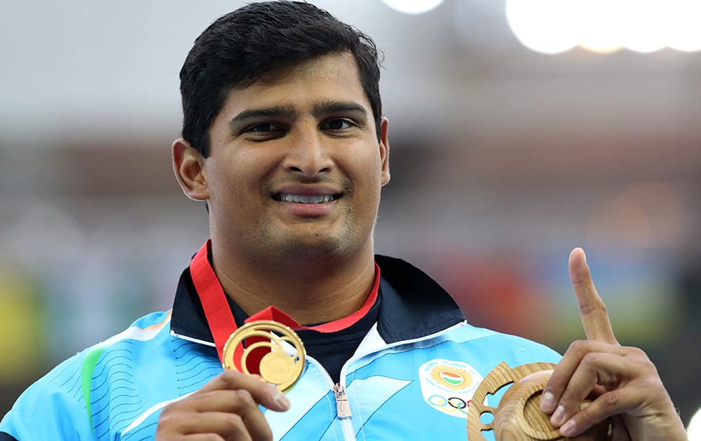 Vikas Shive Gowda of India holds up his gold medal for the men's discus throw following the medal ceremony at Hampden Park Stadium during the Commonwealth Games 2014 in Glasgow, Scotland.