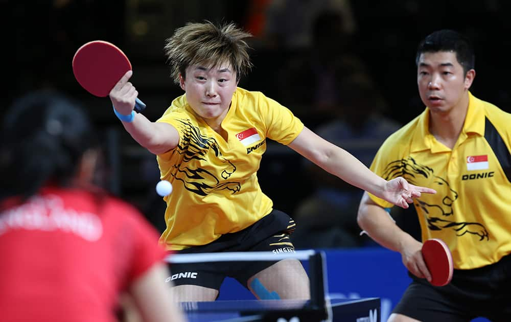 Singapore's Jian Zhan, left, returns a serve as Tianwei Feng looks on during their mixed doubles semi-final match against England's Liam Pitchford and Tin Tin Ho at Hampden Park Stadium during the Commonwealth Games 2014 in Glasgow, Scotland.