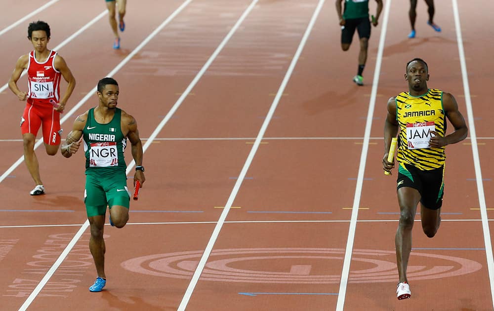 Usain Bolt of Jamaica, right, brings the baton home as he runs the last leg of his first round heat of the men's 4 by 100 meter relay in Hampden Park stadium during the Commonwealth Games 2014 in Glasgow.