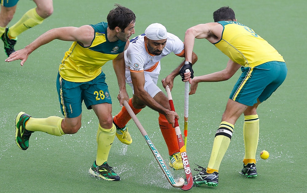 Australia's Kiel Brown, left, Mark Knowles, right, and India's Gurwinder Chandi challenge for the ball during the gold medal hockey match between India and Australia at the Commonwealth Games 2014 in Glasgow, Scotland.