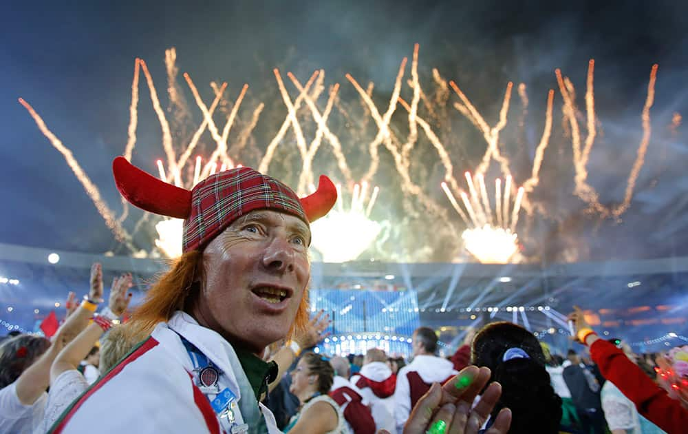 A man wearing a tartan hat watches as fireworks explode during the Closing Ceremony for the Commonwealth Games Glasgow 2014, at Hampden Park stadium, in Glasgow, Scotland.