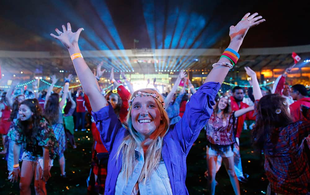 A cast member holds up her arms as she dances during the Closing Ceremony for the Commonwealth Games Glasgow 2014, at Hampden Park stadium, in Glasgow, Scotland.