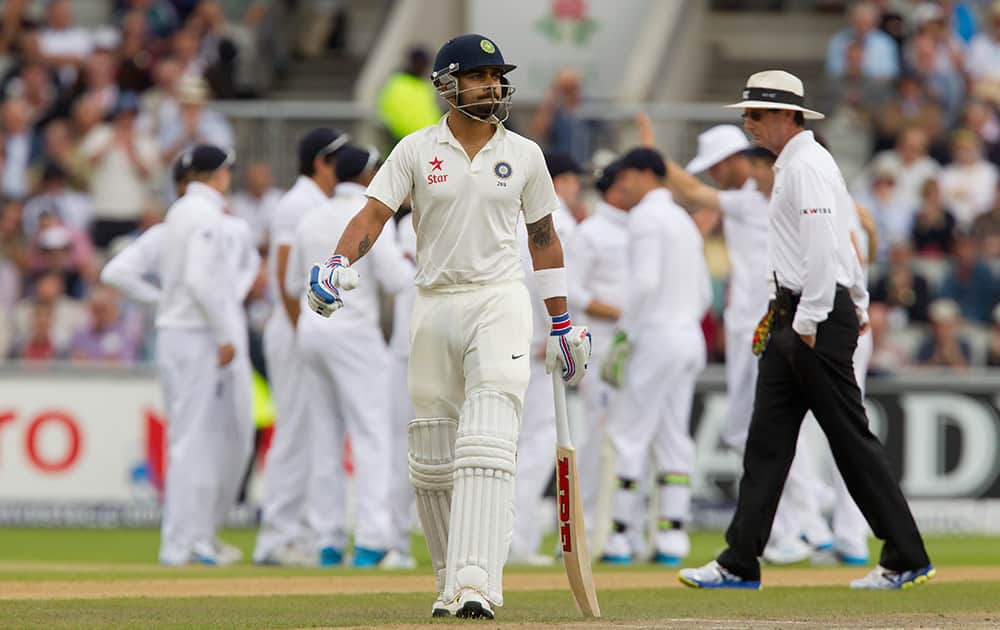 India's Virat Kohli walks from the pitch after losing his wicket for 0 off the bowling of England's James Anderson at Old Trafford cricket ground on the first day of the fourth test match of their five match series, in Manchester, England.