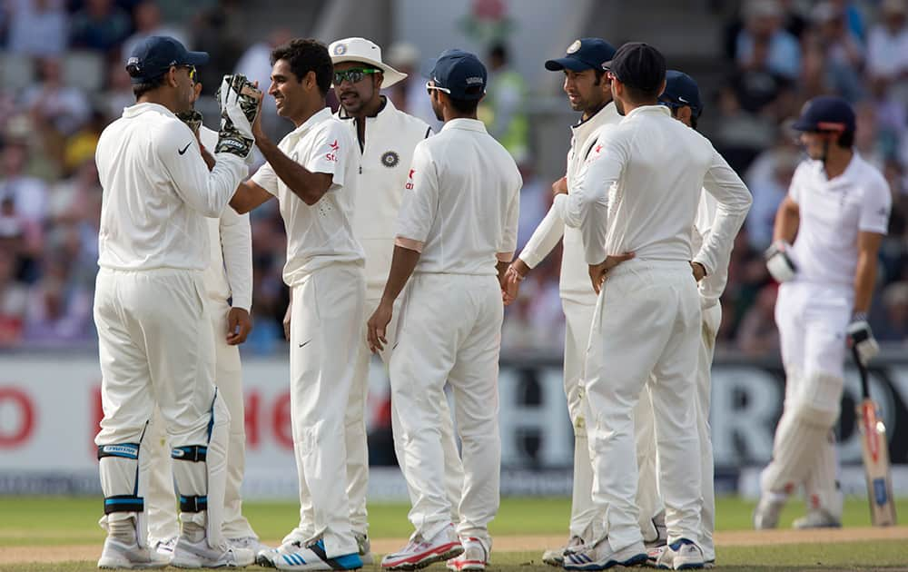 Bhuvneshwar Kumar, second left, celebrates with teammates after taking the wicket of England's Sam Robson for 6 on the first day of the fourth test match of their five match series at Old Trafford cricket ground, in Manchester, England.