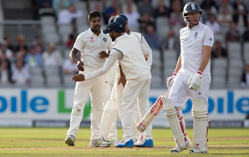 Varun Aaron, left, celebrates after taking the wicket of England's Gary Ballance, right, lbw for 37 on the first day of the fourth Test match of their five match series at Old Trafford cricket ground, in Manchester, England.