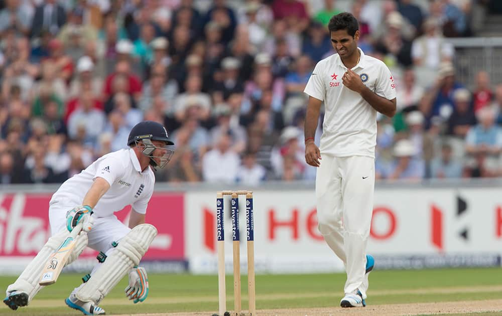 Bhuvneshwar Kumar, right, walks back to his mark as England's Ian Bell takes a run at Old Trafford cricket ground on the second day of the fourth test match of their five match series, in Manchester, England.