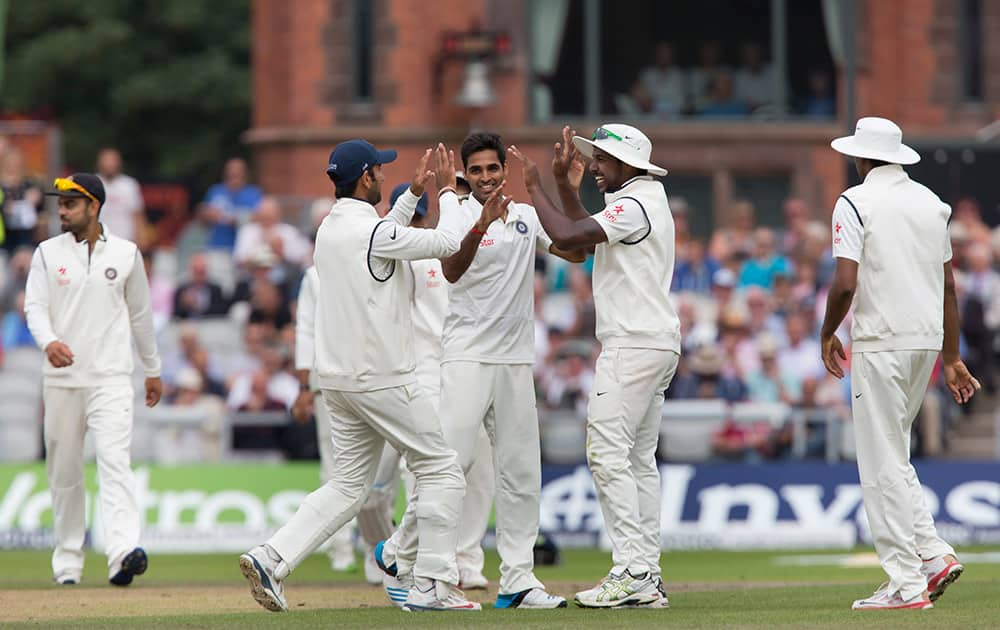 Bhuvneshwar Kumar, centre, celebrates with teammates after taking the wicket of England's Chris Jordan for 13 at Old Trafford cricket ground on the second day of the fourth test match of their five match series, in Manchester, England.