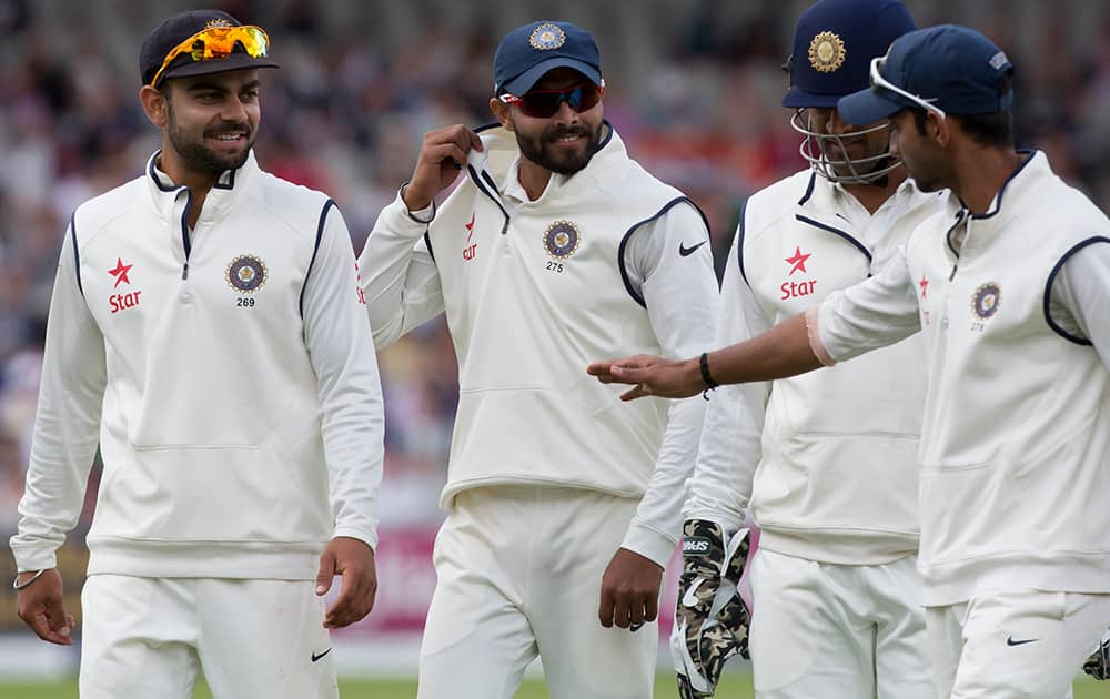 India's Ravindra Jadeja smiles he walks from the pitch with teammates after taking the wicket of James Anderson for 9, as England post a total of 367 on the third day of the fourth test match of their five match series at Old Trafford cricket ground, in Manchester, England.