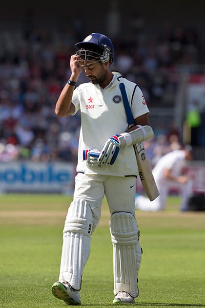 India's Murali Vijay walks from the pitch after losing his wicket off the bowling of England's Chris Woakes, lbw for 18, on the third day of the fourth test match of their five match series at Old Trafford cricket ground, in Manchester, England.