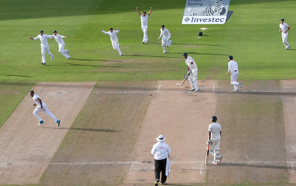 England's Chris Jordan, center left, celebrates after taking India's last wicket, that of Pankaj Singh, upper center right, bowled first ball, at Old Trafford cricket ground on the third day of the fourth test match of their five match series against England, in Manchester, England.