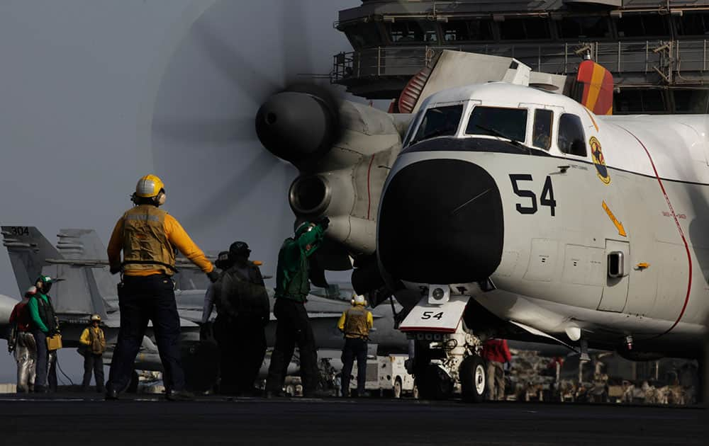 Sailors guide a military plane on the flight deck of the US Navy aircraft carrier USS George H.W. Bush in the Persian Gulf. 