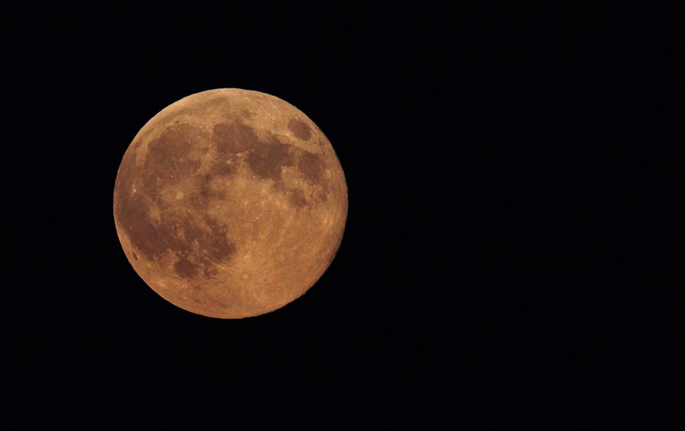 The supermoon appears yellow as the sky darkens over Edgartown, Mass., on the island of Martha`s Vineyard. President Barack Obama and his family are vacationing on the island. 