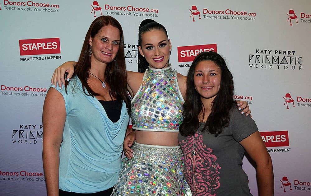 Global pop star Katy Perry, center, with local teacher, Kendra Lincourt, left, and student Carmen Ramirez, right, backstage at the The Palace of Auburn Hills during her Prismatic World Tour performance in Auburn Hills, Mich.