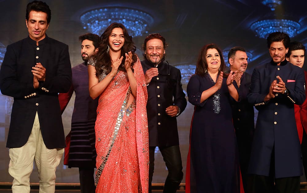 Bollywood actors Sonu Sood, Abhishek Bachchan, Deepika Padukone, Jackie Shroff, Director Farah Khan, Boman Irani, Shah Rukh Khan and Vivaan Shah applaud during a promotional event for their upcoming film 'Happy New Year' in Mumbai.