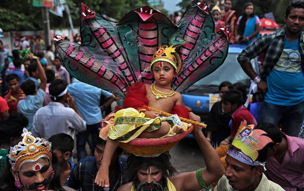 A Bangladeshi Hindu devotee carries on his head, a child dressed like Hindu god Krishna in a basket during a procession to celebrate ‘Janmashtami’ or Krishna’s birth day in Dhaka, Bangladesh.