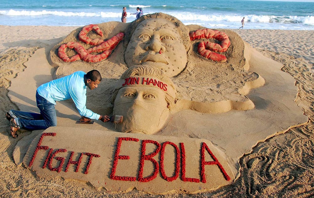 Sand artist Sudarsan Pattnaik creates a sand sculpture on EBOLA virus with a message “Join hands to fight EBOLA” at Puri beach in Odisha.