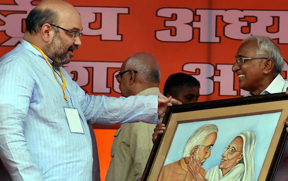 BJP National President Amit Shah is presented with a painting of Prime Minister Narendra Modi and his mother during a party workers` meeting in Lucknow.