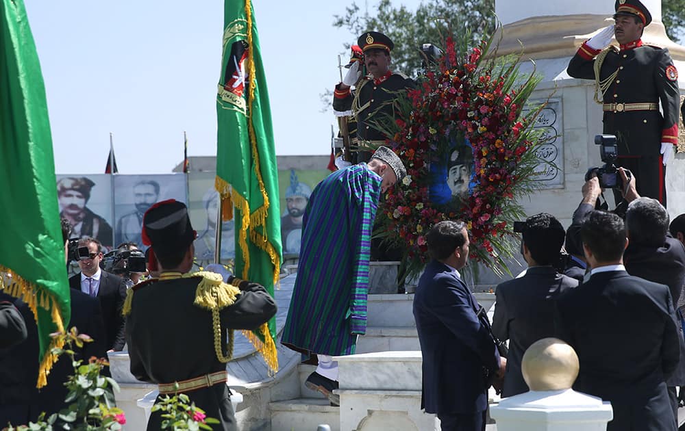 Afghan president Hamid Karzai, puts flowers on the `Independence Minaret` monument during the Independence Day ceremony in Kabul, Afghanistan.