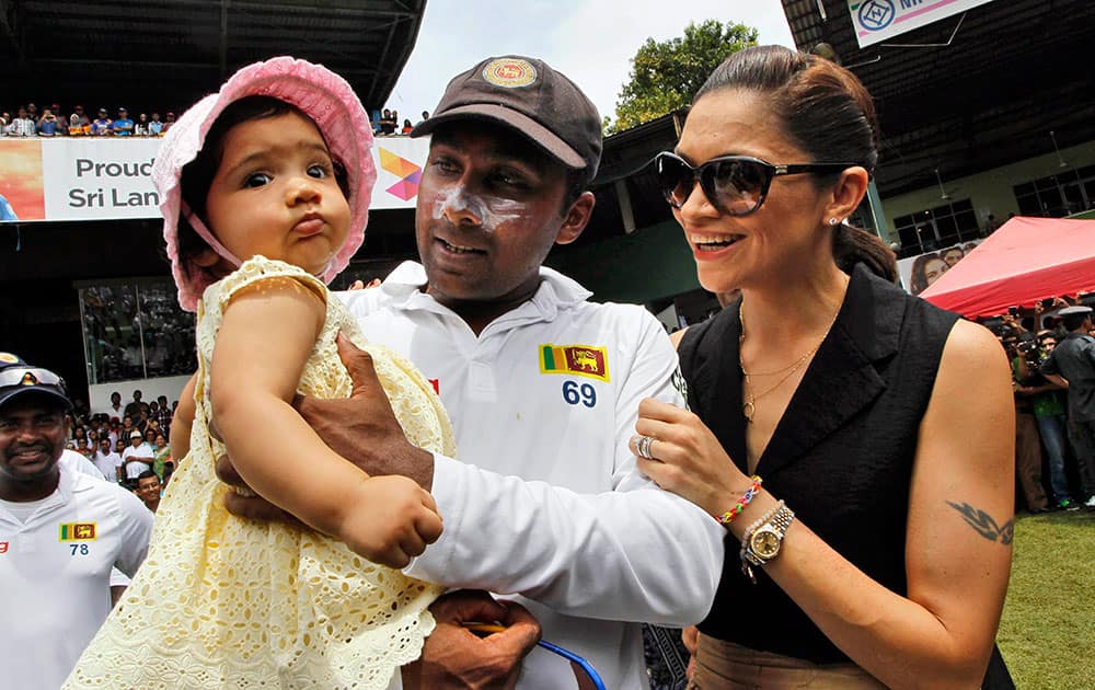 Sri Lanka`s Mahela Jayawardene holds his daughter Sansa as wife Christina watches at the end of the second cricket test match against Pakistan in Colombo, Sri Lanka.