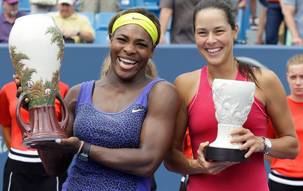 Serena Williams and Ana Ivanovic, from Serbia, pose with their trophies after Williams defeated Ivanovic 6-4, 6-1, in the women`s final match at the Western & Southern Open tennis tournament.