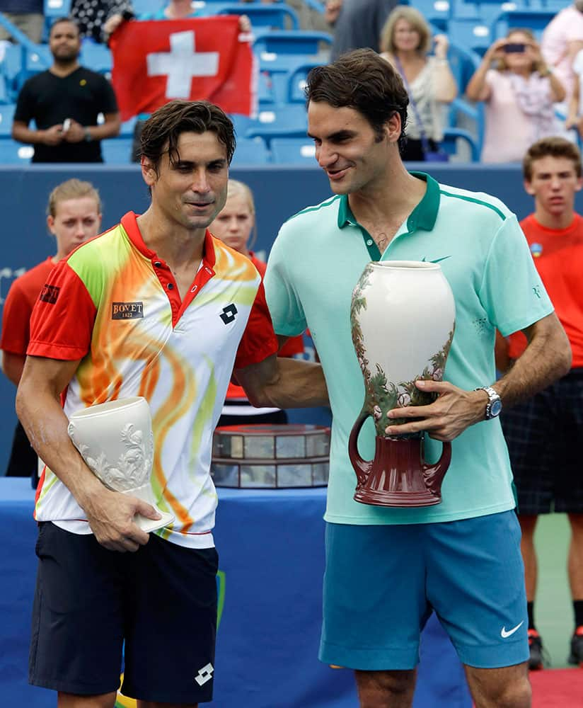 David Ferrer, from Spain, left, and Roger Federer, from Switzerland, congratulate each other as they pose with their trophies after Federer defeated Ferrer 6-3, 1-6, 6-2, to win the Western & Southern Open tennis tournament.