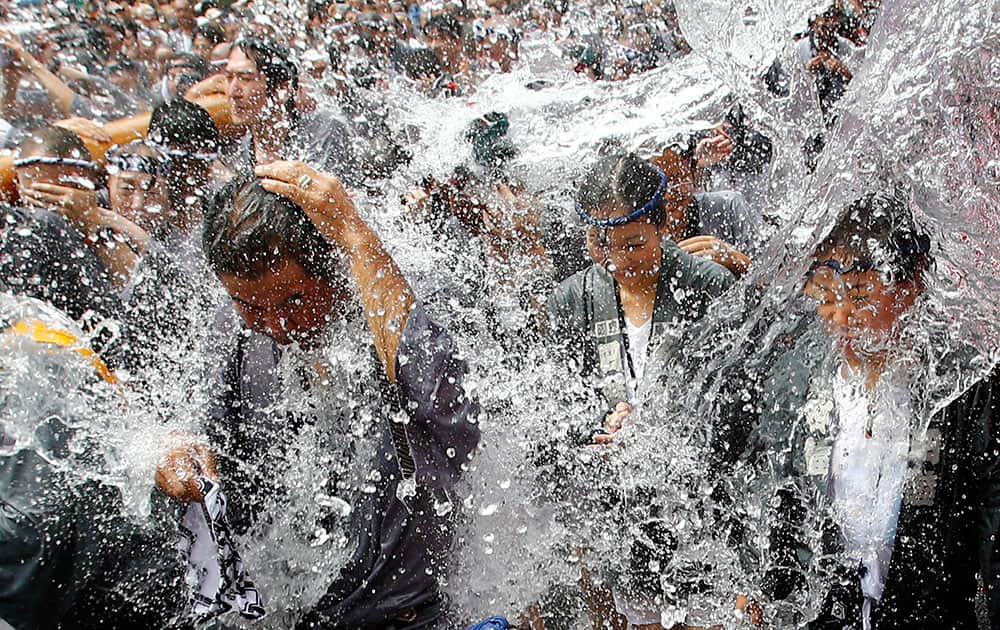 Festivalgoers are splashed with water during a summer festival of Tomioka Hachimangu Shrine in downtown Tokyo.