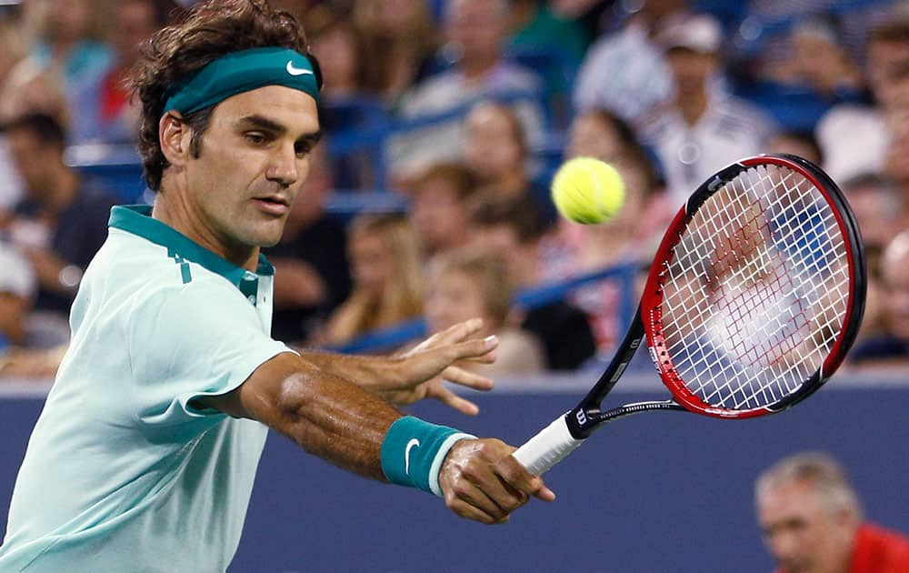 Roger Federer, from Switzerland, returns a volley to Milos Raonic, from Canada, during a semifinal at the Western & Southern Open tennis tournament.