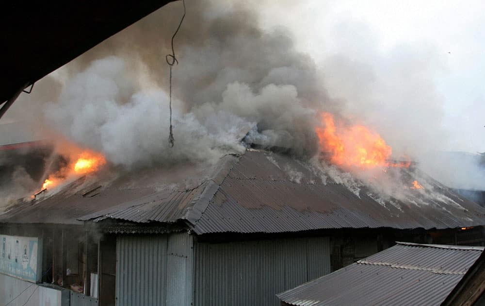 Flames rise from the residential houses and shopping complex during a major fire which gutted several Residential Houses and a Shopping Complex, at Kokar Bazar in Srinagar.