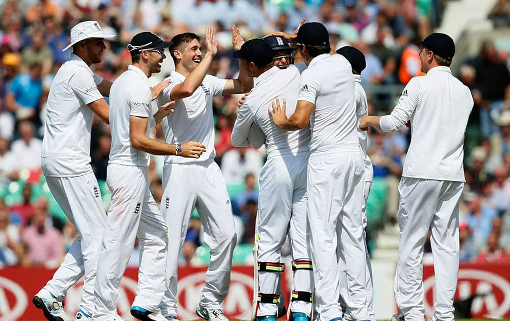 England's Chris Woakes, centre, celebrates with teammates after taking the wicket of India's Murali Vijay during the first day of the fifth test cricket match at Oval cricket ground in London.