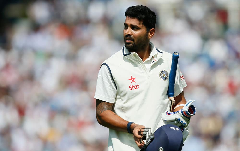 Murali Vijay looks at a large video screen to see how he lost his wicket, caught out by England's Joe Root off the bowling of Chris Woakes, during the first day of the fifth test cricket match at Oval cricket ground in London.