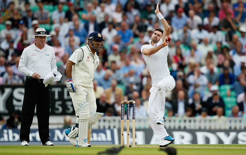 England's James Anderson, right, bowls to India's Stuart Binny during the first day of the fifth test cricket match at Oval cricket ground in London.