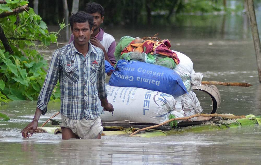 Villagers use a banana raft to reach a safer place following floods at Bhurbandha in Nagaon district of Assam.