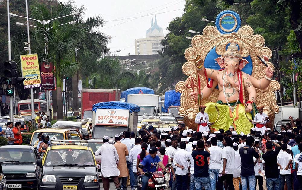 Devotees carry a Ganesh idol to the pandal for the upcomming Ganesh festival in Mumbai.