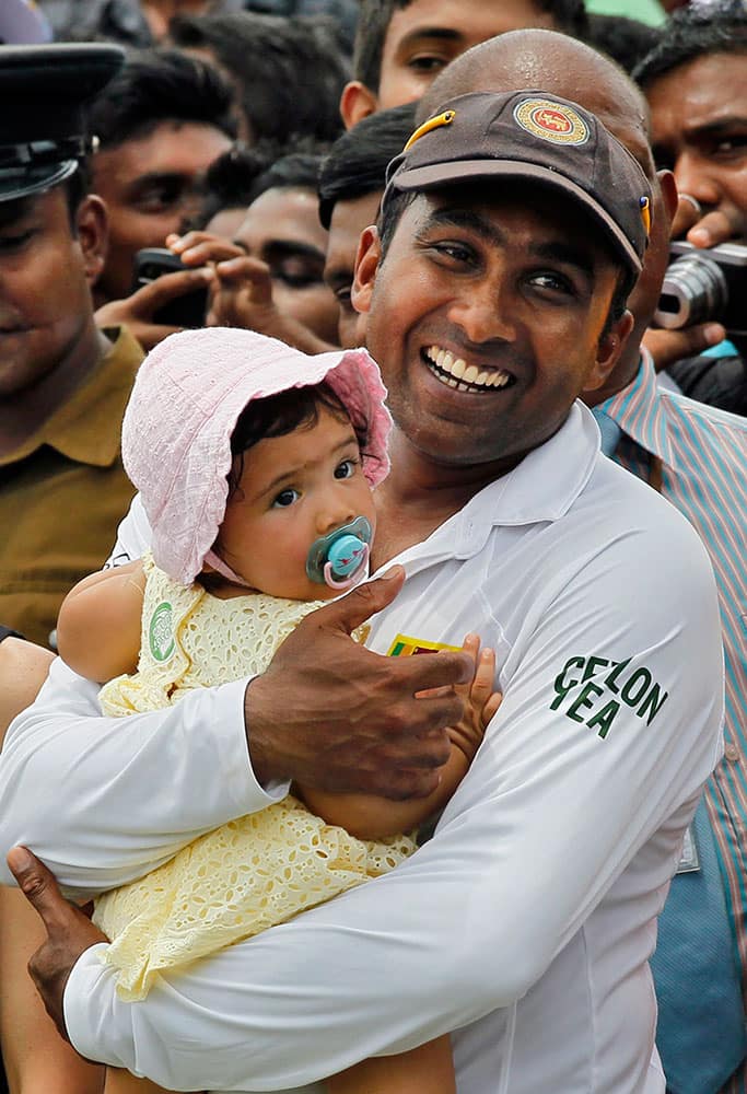 Sri Lanka's Mahela Jayawardene smiles as he holds his daughter Sansa at the end of the second cricket test match against Pakistan in Colombo, Sri Lanka.