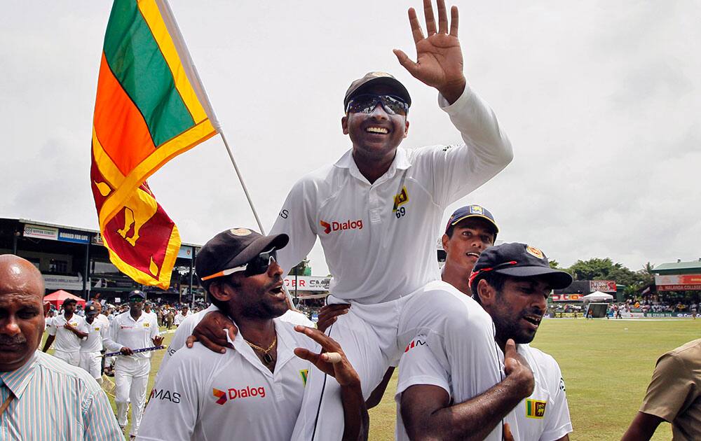 Sri Lanka’s Mahela Jayawardene, center, is carried by teammates Chanaka Welegedara, left, and Dhammika Prasad as they celebrate winning their second cricket test match against Pakistan by 105 runs, in Colombo, Sri Lanka.