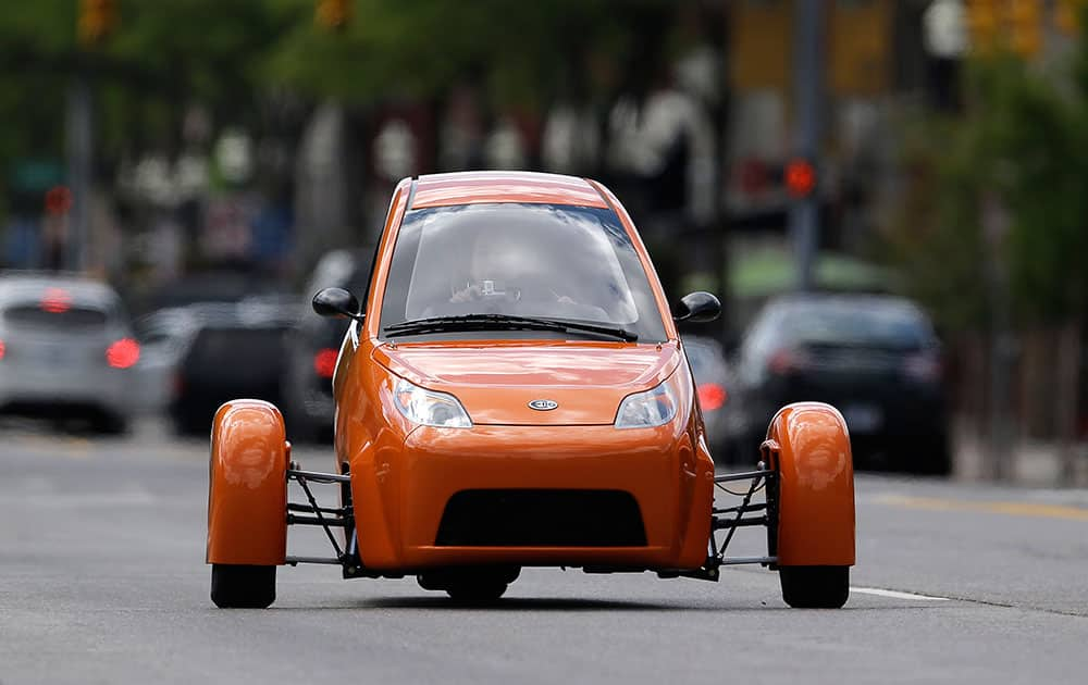 The Elio, a three-wheeled prototype vehicle, is shown in traffic in Royal Oak, Mich.