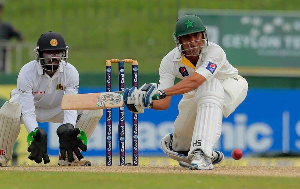 Pakistani cricketer Younis Khan bats as Sri Lanka`s Niroshan Dickwella watches during the second day of the second test cricket match between Sri Lanka and Pakistan in Colombo, Sri Lanka.