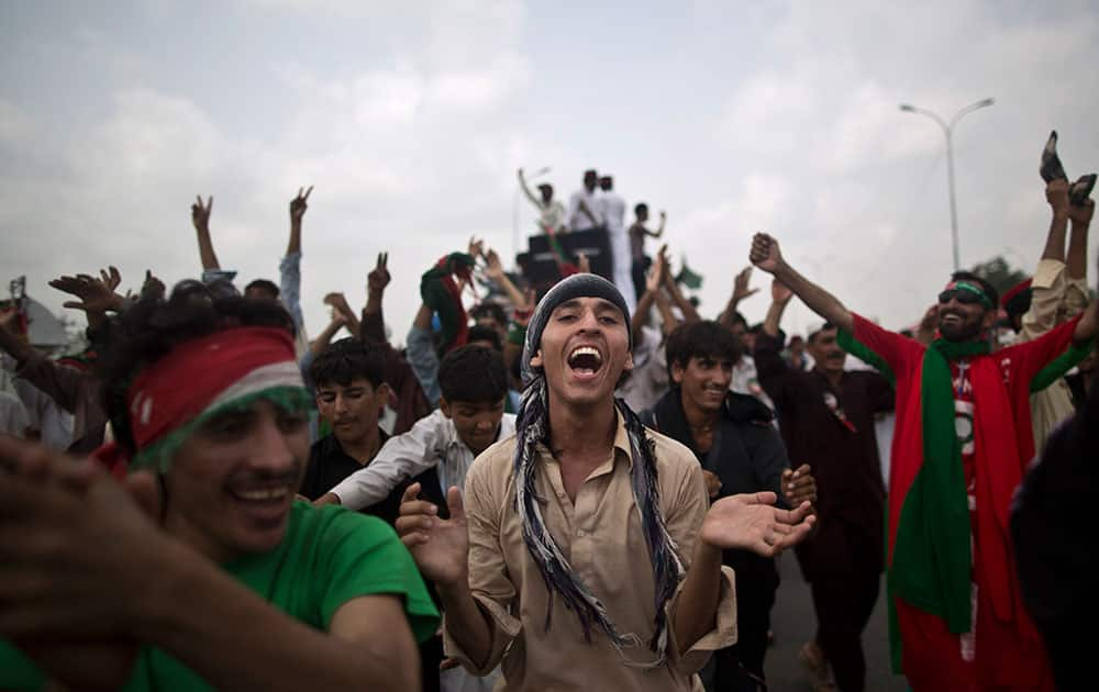 Supporters of Pakistan`s cricketer-turned-politician Imran Khan, chant slogans, while waiting for other supporters marching to Islamabad from Lahore, in Islamabad.