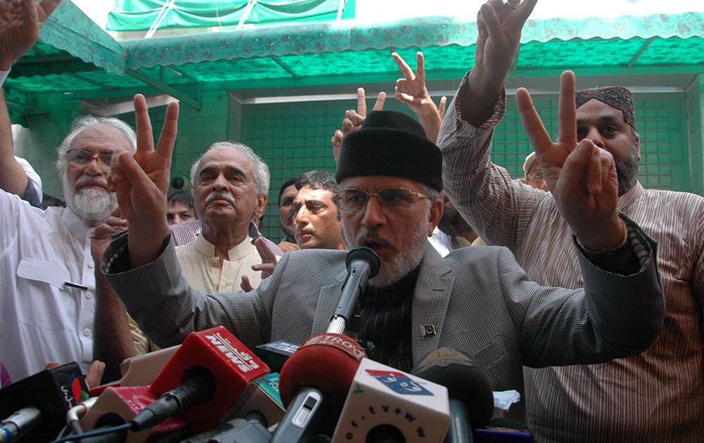 Pakistani anti-goverment cleric Tahir-ul-Qadri, center, gestures ahead of a march to Islamabad from Lahore, Pakistan.