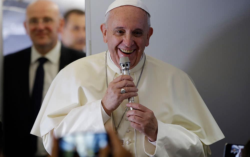 Pope Francis smiles as he meets journalists aboard the papal flight on the journey to Seoul, South Korea.