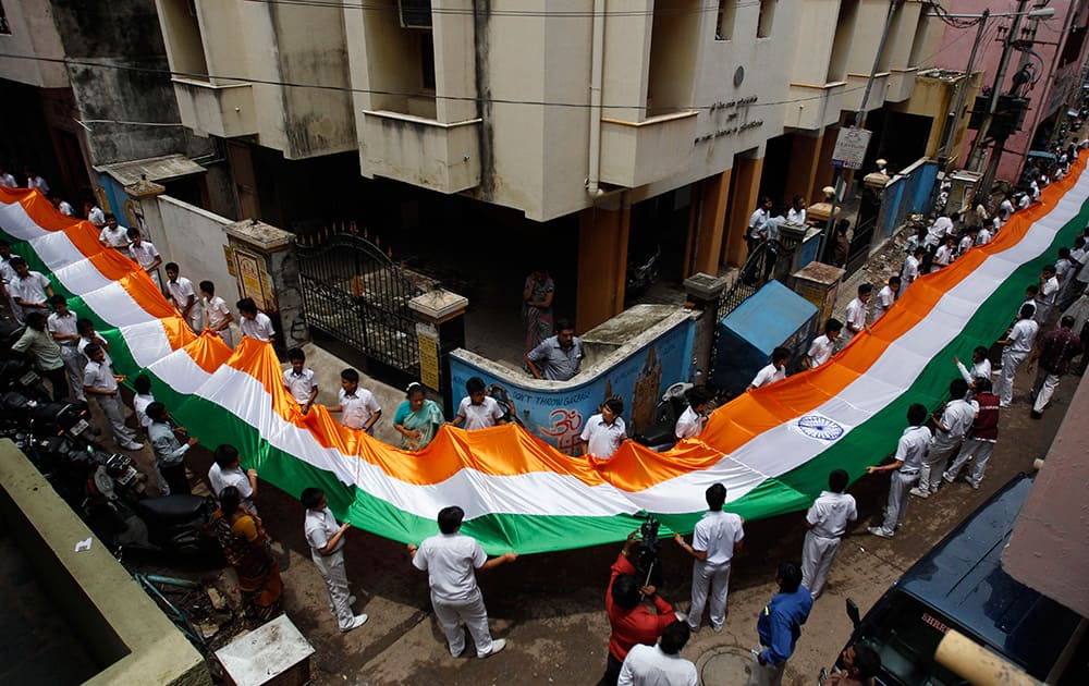 School children carry a 200 feet (61 meters) long Indian National flag through an alley as part of Independence Day celebrations in Chennai.