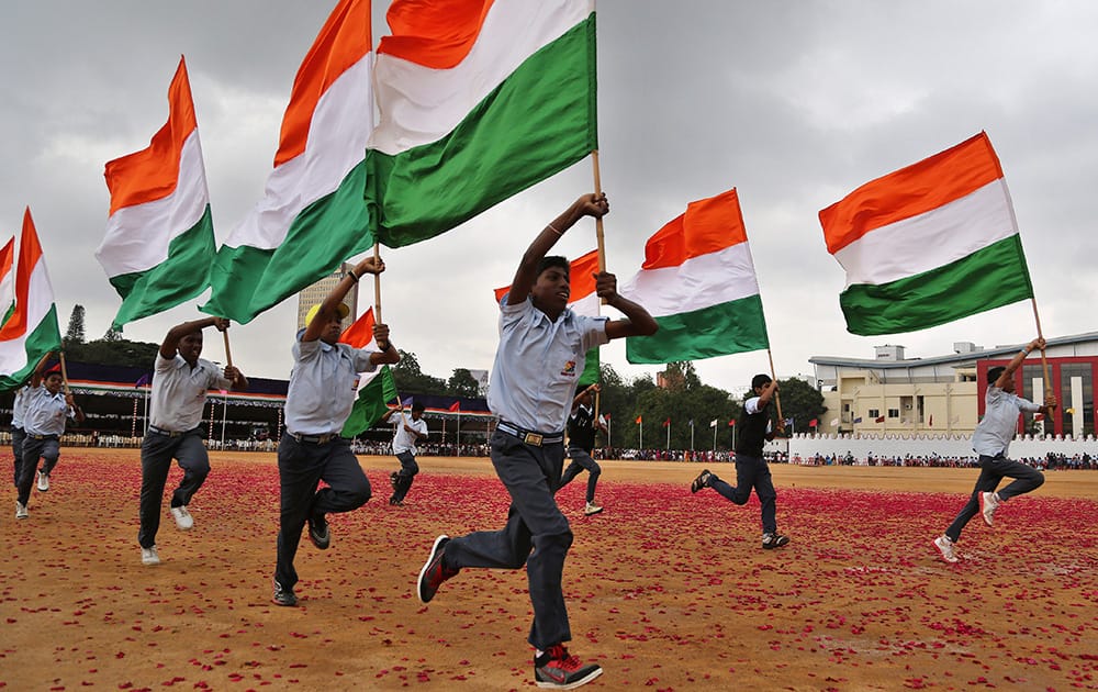 School children run with the national tricolor flags as they rehearse for the Independence Day celebrations in Bangalore.