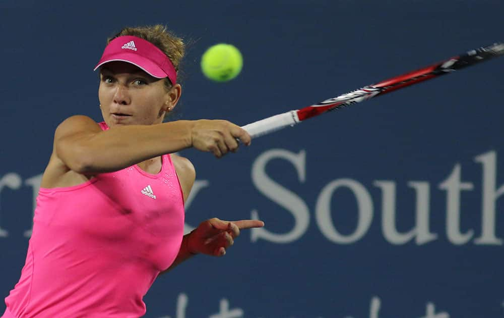 Simona Halep, of Romania, returns a volley to Kirstenm Flipkens, of Belgium, at the Western & Southern Open tennis tournament.