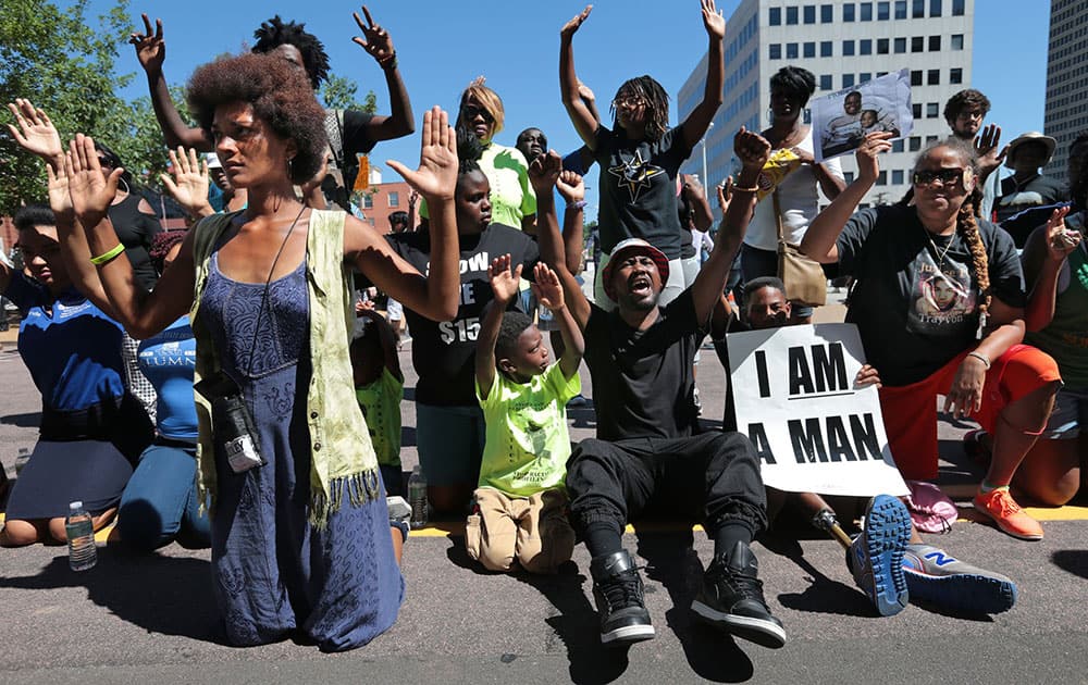 Protestors drop to their knees and put their arms in the air during a rally for Michael Brown Jr., who was shot and killed by a Ferguson police officer in Clayton, Mo. 