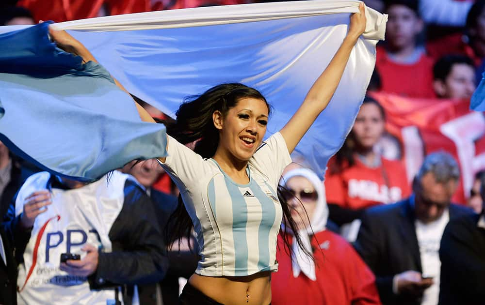 A performer holds an Argentine flag during a rally in support of the Argentine government in their dispute against a U.S. hedge fund, known as `vulture funds,` in Buenos Aires, Argentina.