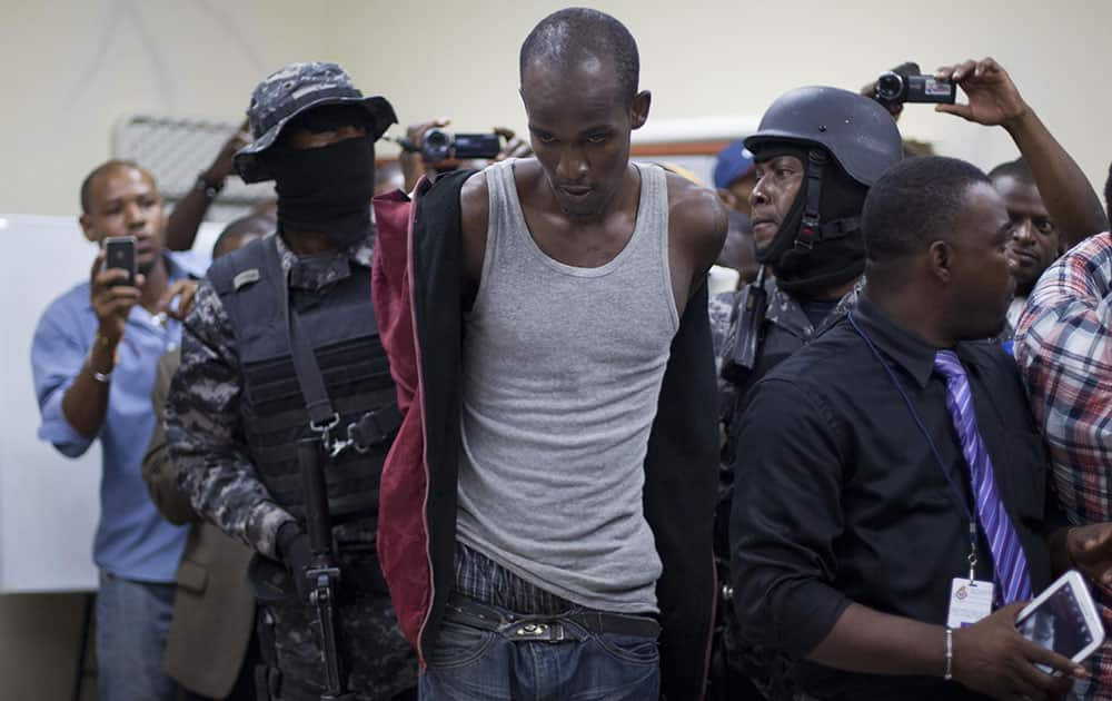 Toussaint Richardson, center, is escorted by police after his arrest in Port-au-Prince, Haiti.