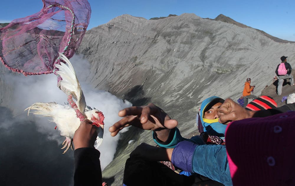 Villagers catch offering of a chicken thrown by Hindu worshippers into the crater of Mount Bromo in Probolinggo, East Java, Indonesia.