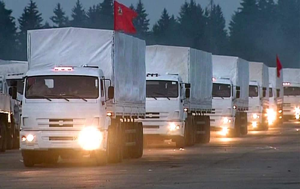 In this image taken from video a convoy of white trucks with humanitarian aid leaves Alabino, outside Moscow. The convoy of 280 Russian trucks headed for eastern Ukraine early Tuesday, one day after agreement was reached on an international humanitarian relief mission. 