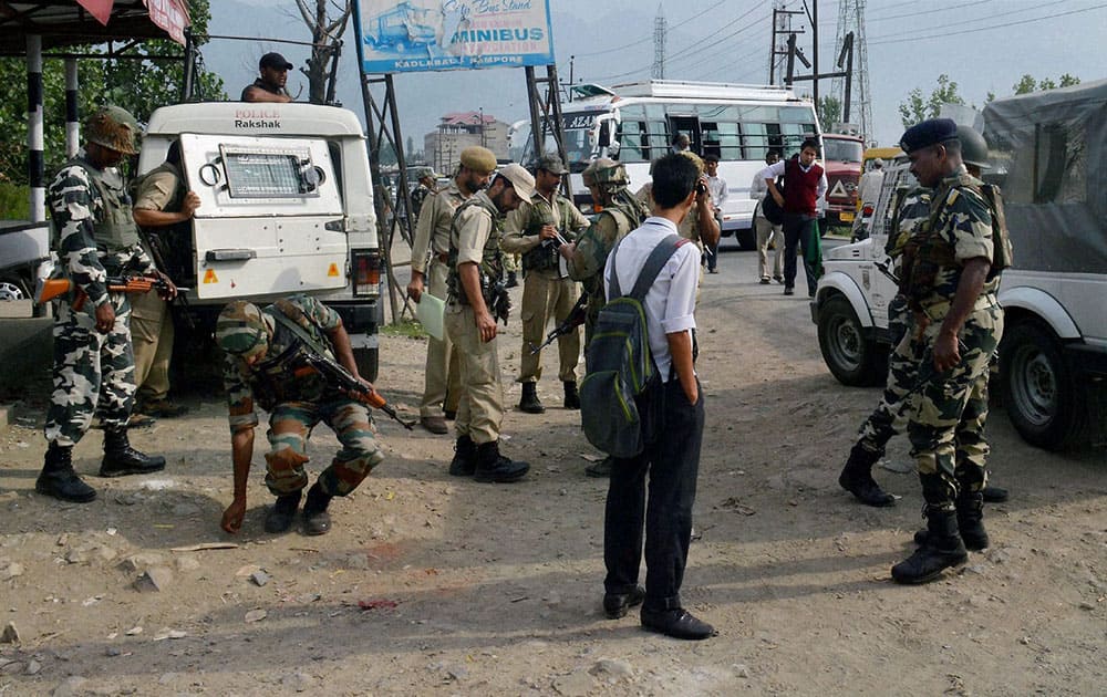 Army personnel inspecting on Tuesday the spot where a BSF convoy was attacked by militants on Monday evening near Pampore.